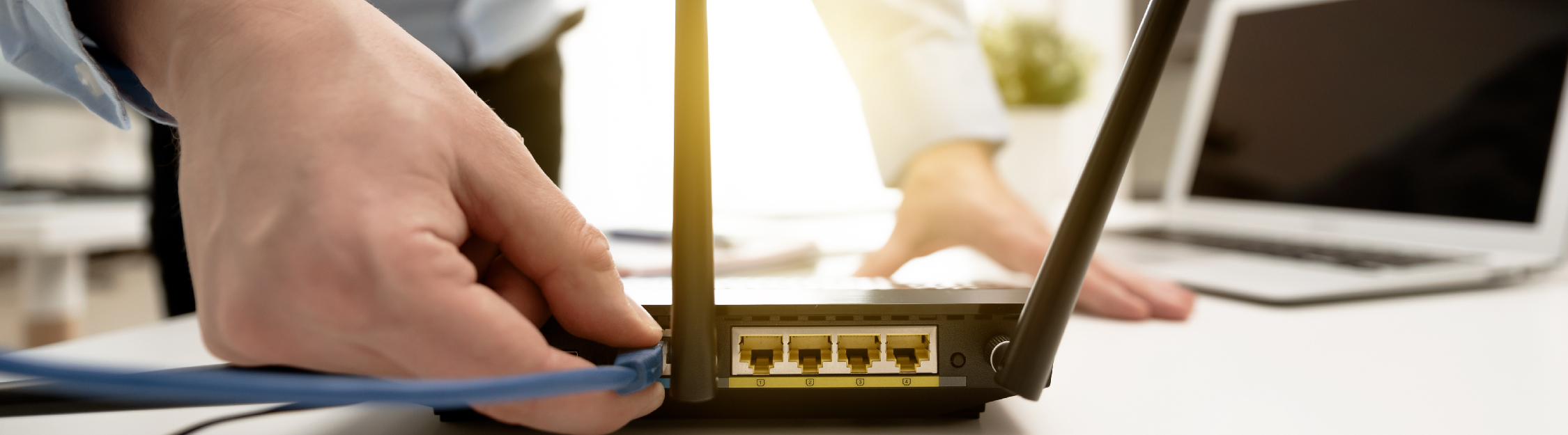 Service tech connects ethernet cord to WiFi router